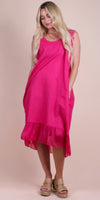 Woman wearing a sleeveless hot pink linen dress with lace accents and ruffled hem