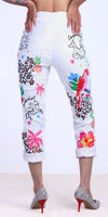 White cropped pants with colorful tropical and animal print designs, worn with striped heels