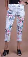 White floral print drawstring pants with rolled cuffs, worn by model in black top and heels