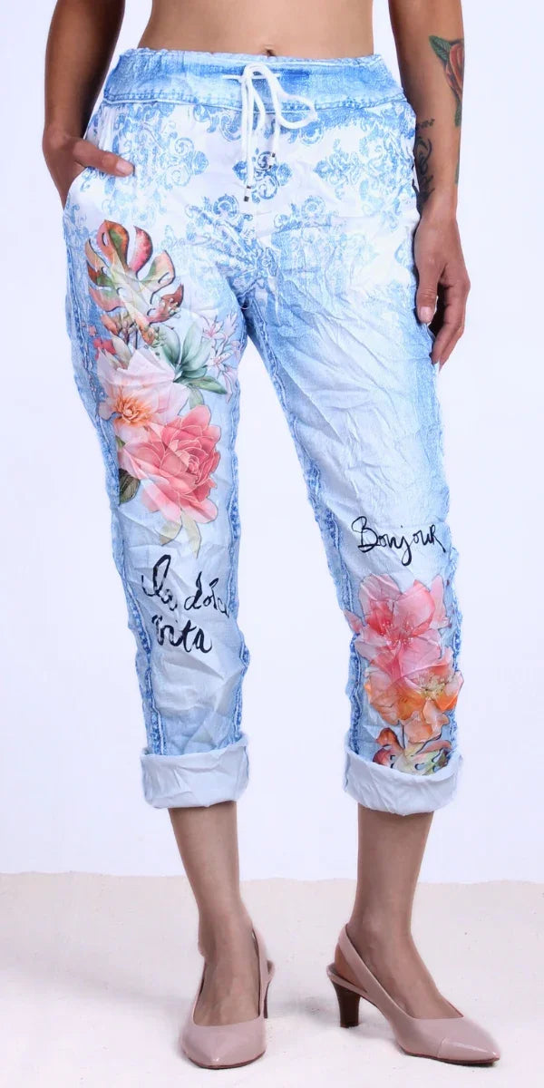 Woman wearing light blue floral print drawstring jogger pants with rolled cuffs