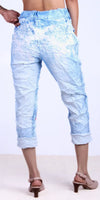 Back view of woman wearing light blue patterned crinkle pants with cuffed hems and heels