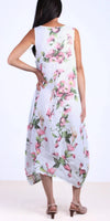 Woman wearing sleeveless white linen dress with pink floral print, back view