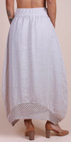 Back view of a light linen maxi skirt with crochet lace hem, worn with tan heels