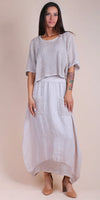 Woman wearing a beige crochet knit top with a matching linen maxi skirt and nude heels