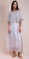 Woman wearing light beige linen maxi skirt with crochet details and two front pockets