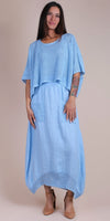 Woman wearing light blue linen dress with crochet top, front pockets, and tan heels