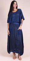 Woman wearing a navy linen maxi dress with crochet knit top, patch pockets, and tan heels