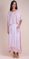 Woman wearing a light pink linen maxi dress with crochet overlay and front pockets