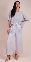 Woman wearing loose knit top with wide-leg linen pants and block heels