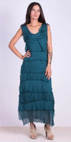 Woman wearing teal sleeveless tiered maxi dress with raw edge details and open-toe heels