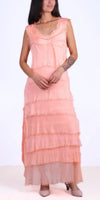 Woman wearing sleeveless peach tiered maxi dress with raw edges, neutral heels, and layered necklace