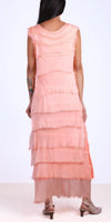 Back view of woman wearing sleeveless peach tiered maxi dress with frayed edges