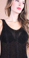 Woman wearing a sleeveless black knit mesh tank top with textured pattern
