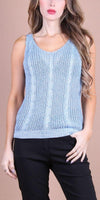Woman wearing light blue sleeveless knit tank top with cable pattern and black pants