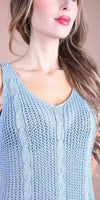 Light blue sleeveless knit top with cable details and V-neck, modeled by a woman