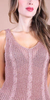Woman wearing a pink sleeveless knit top with cable knit patterns