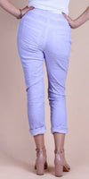 Back view of woman in light purple linen pants with rolled cuffs and nude block heels