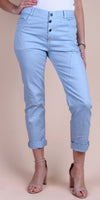 Light blue linen women's pants with rolled cuffs and button front, paired with heels