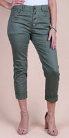 Woman wearing olive green high-waisted cropped pants with rolled cuffs and button front