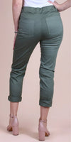 Woman wearing green cropped pants with cuffed hems and back pockets, paired with nude heels