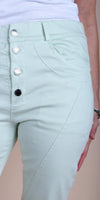 Light mint green high-waisted pants with silver buttons and front pockets