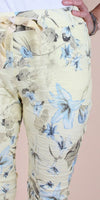 Yellow drawstring pants with blue and grey floral print, close-up view
