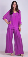 Woman wearing a loose-fit magenta silk top with wide-leg pants and necklace