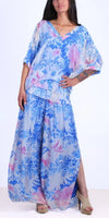 Woman wearing a flowy blue and pink floral print blouse and palazzo pants set.