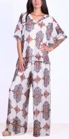 Woman wearing loose fit floral patterned silk blouse and wide-leg pants set