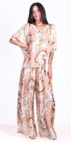 Woman wearing beige paisley print flowy silk blouse and wide-leg pants set
