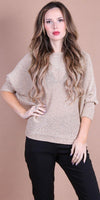 Woman wearing a beige knit sweater with three-quarter sleeves and black pants