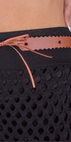 Closeup of black mesh skirt with tan belt and bow detail at the waist