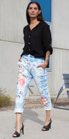 Woman in black button-up blouse and floral print jogger pants, stylish outdoor look
