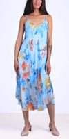 Woman wearing a light blue floral silk midi dress with spaghetti straps, summer fashion