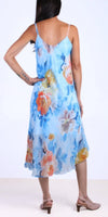 Woman wearing a sleeveless blue floral midi dress with strappy heels, viewed from behind