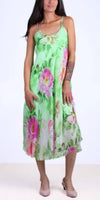 Woman wearing a green floral silk midi dress with spaghetti straps