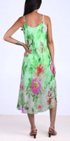 Woman in a green floral silk midi dress with spaghetti straps and open back, wearing heels