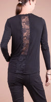 Black long sleeve blouse with sheer lace back panel, worn by woman in black pants