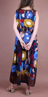 Woman wearing a sleeveless maxi dress with colorful abstract floral print, back view