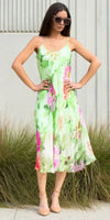 Woman wearing a sleeveless green floral print silk midi dress outdoors