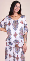 Woman wearing a white Italian silk blouse and skirt with colorful baroque print