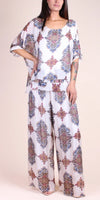 Woman wearing white wide-leg pants and top set with colorful baroque pattern