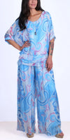 Woman in flowy blue and pink abstract print Italian silk blouse and palazzo pants set
