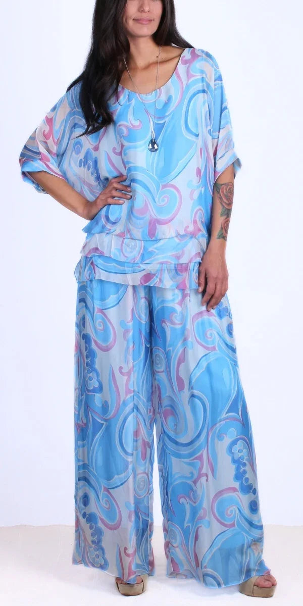 Woman in flowy blue and pink abstract print Italian silk blouse and palazzo pants set