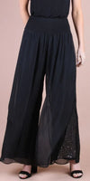 Woman wearing black wide-leg palazzo pants with sheer overlay and sequin detail
