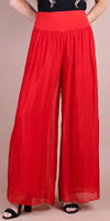 Woman wearing high waist red wide leg palazzo pants with flowy sheer fabric