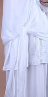 White sequin-embellished blouse with sheer draping and tie detail, close-up view