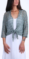 Woman wearing sage green lace knit tie-front cardigan over white dress
