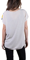 Back view of a woman wearing a loose-fitting beige short sleeve blouse with black pants