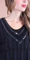 Close-up of woman wearing black lace top with sequin-embellished V-neckline